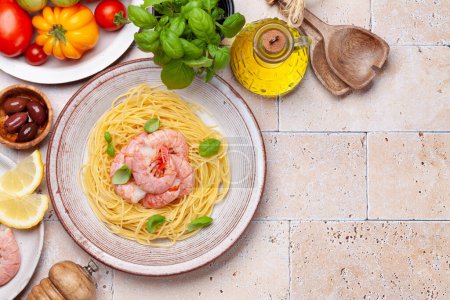 Téléchargez les photos : Pâtes aux crevettes et diverses tomates de jardin. Cuisine italienne. Pose plate avec espace de copie - en image libre de droit