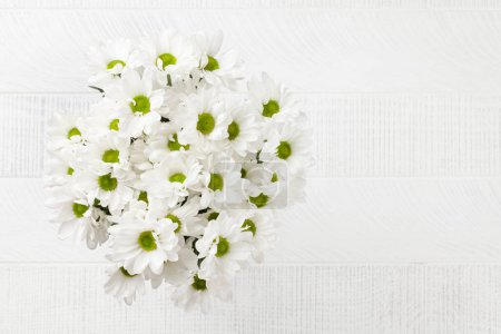 Téléchargez les photos : Bouquet de fleurs de marguerite. Bouquet de fleurs de camomille sur fond en bois. Vue du dessus plat avec espace de copie - en image libre de droit