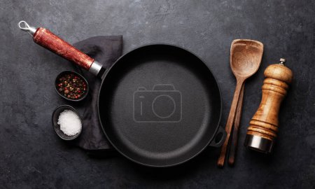 Foto de Sartén vacía, utensilios de cocina y especias. Vista superior plano laico - Imagen libre de derechos