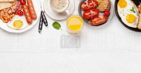 Photo for English breakfast with fried eggs, beans, bacon and sausages. Coffee and orange juice. Top view flat lay with copy space - Royalty Free Image