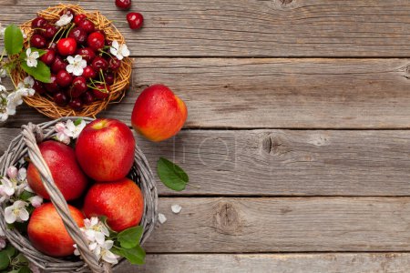 Foto de Manzanas rojas maduras y cereza sobre mesa de madera. Vista superior plano con espacio de copia - Imagen libre de derechos