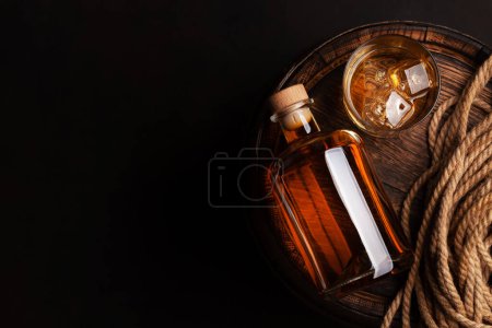 Foto de Botella con ron, coñac o whisky. Sobre un viejo barril de madera. Vista superior plano con espacio de copia - Imagen libre de derechos