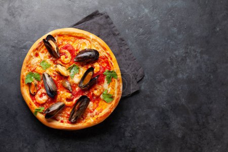 Téléchargez les photos : Cuisine italienne. Pizza aux fruits de mer. Pose plate sur table en pierre avec espace de copie - en image libre de droit
