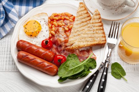 Foto de Desayuno inglés con huevos fritos, frijoles, tocino y salchichas. Vista superior - Imagen libre de derechos