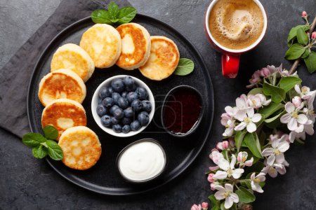 Photo for Cottage pancakes with berry jam, sour cream and berries. Breakfast with coffee. Top view flat lay - Royalty Free Image