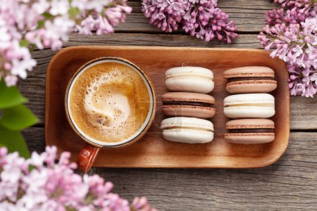Photo for Macaroon cookies and coffee. On wooden table with lilac flowers. Top view flat lay - Royalty Free Image