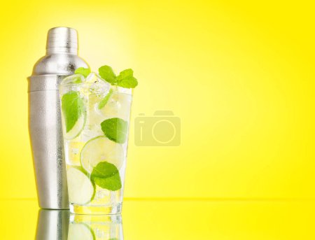 Photo for Mojito cocktail and cocktail shaker on yellow background with copy space - Royalty Free Image