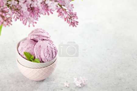 Téléchargez les photos : Crème glacée sundae bol et fleurs lilas. Avec espace de copie - en image libre de droit