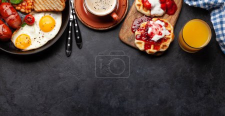 Téléchargez les photos : Petit déjeuner anglais avec œufs frits, haricots, bacon et saucisses. Café et jus d'orange. Vue du dessus plat avec espace de copie - en image libre de droit