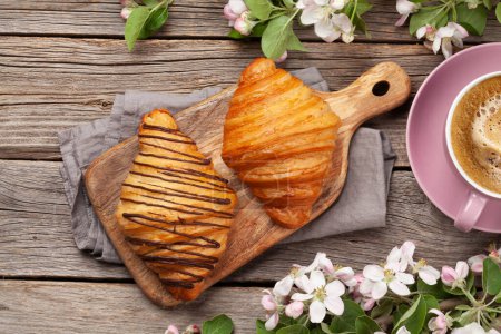 Foto de Varios croissants y café sobre tabla de madera. Desayuno francés. Vista superior plano laico - Imagen libre de derechos