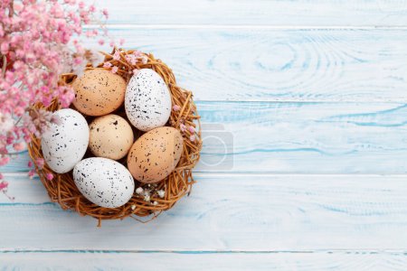 Foto de Tarjeta de felicitación de Pascua con huevos de Pascua en el nido. Vista superior plano con espacio de copia - Imagen libre de derechos