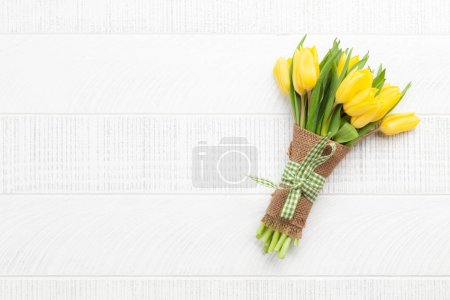 Foto de Ramo de flores de tulipán amarillo sobre mesa de madera. Vista superior plano con espacio de copia - Imagen libre de derechos