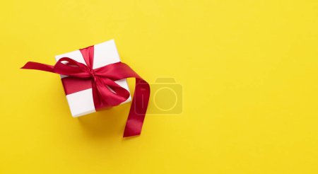 Photo for Gift box on yellow background. Flat lay with copy space - Royalty Free Image