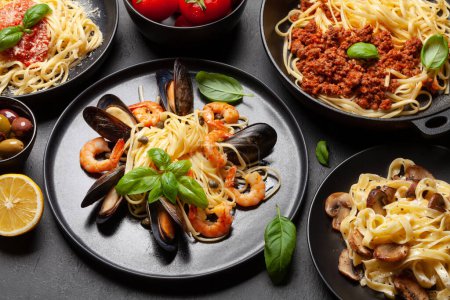 Foto de Varias pastas italianas. Pasta de mariscos, champiñones y salsa de tomate, espaguetis boloñeses - Imagen libre de derechos