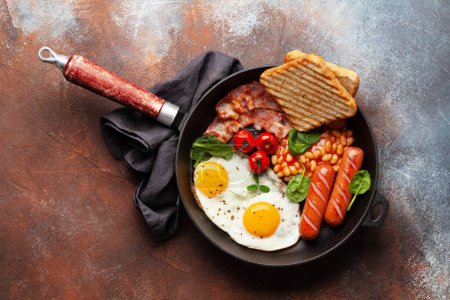 Photo for English breakfast with fried eggs, beans, bacon and sausages. Top view flat lay with copy space - Royalty Free Image