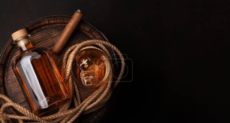 Téléchargez les photos : Bouteille avec rhum, cognac ou whisky. Sur un vieux tonneau de bois. Vue du dessus plat avec espace de copie - en image libre de droit
