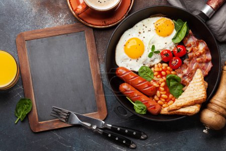 Téléchargez les photos : Petit déjeuner anglais avec œufs frits, haricots, bacon et saucisses. Vue du dessus plat avec espace de copie - en image libre de droit