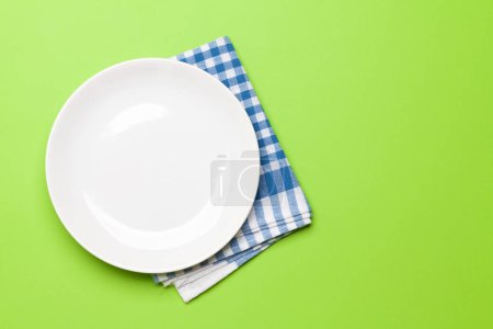 Téléchargez les photos : Assiette vide et serviette sur fond vert. Vue de dessus plat couché avec espace de copie. Modèle ou maquette pour votre repas - en image libre de droit