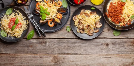 Téléchargez les photos : Différentes pâtes italiennes. Fruits de mer, champignons et sauce tomate pâtes, spaghettis bolognaise. Vue du dessus plat avec espace de copie - en image libre de droit