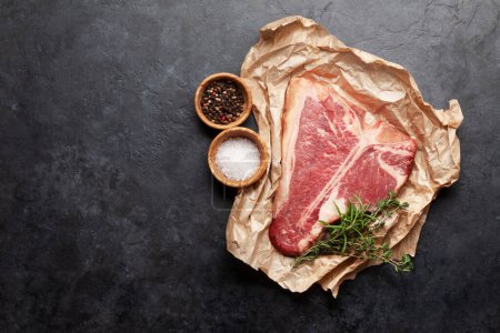 Photo for Porterhouse or T-bone raw beef steak with herbs and spices. Top view flat lay with copy space - Royalty Free Image