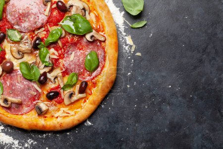 Téléchargez les photos : Cuisine italienne. Pizza Pepperoni. Pose plate sur table en pierre avec espace de copie - en image libre de droit