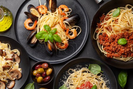 Téléchargez les photos : Différentes pâtes italiennes. Fruits de mer, champignons et sauce tomate pâtes, spaghettis bolognaise. Vue du dessus plat lay - en image libre de droit