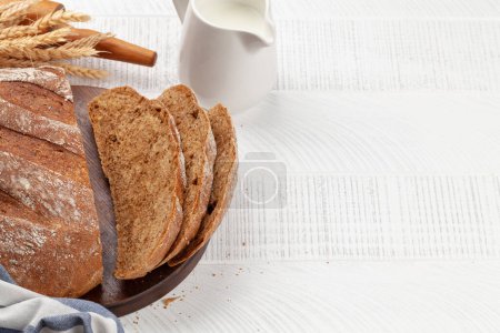 Téléchargez les photos : Trancher le pain fait maison et les ingrédients sur une table en bois. Avec espace de copie - en image libre de droit
