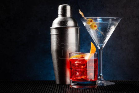 Téléchargez les photos : Cocktail shaker, cocktails negroni et martini sur fond sombre avec espace de copie - en image libre de droit