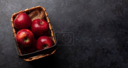 Téléchargez les photos : Pommes mûres rouges dans un panier sur une table en bois. Vue du dessus plat avec espace de copie - en image libre de droit