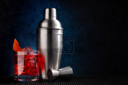 Photo for Cocktail shaker and negroni cocktail on dark background with copy space - Royalty Free Image