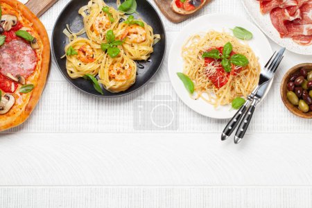Téléchargez les photos : Cuisine italienne. Pâtes, pizza, olives et toasts antipasto. Pose plate avec espace de copie - en image libre de droit