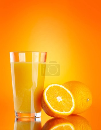 Téléchargez les photos : Jus d'orange frais dans un verre et demi de fruits d'orange sur fond d'orange - en image libre de droit