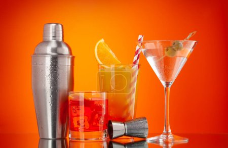 Téléchargez les photos : Cocktail shaker et negroni, tequila sunrise et cocktails martini sur fond orange - en image libre de droit