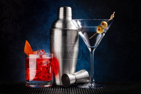Téléchargez les photos : Cocktail shaker, cocktails negroni et martini sur fond sombre - en image libre de droit