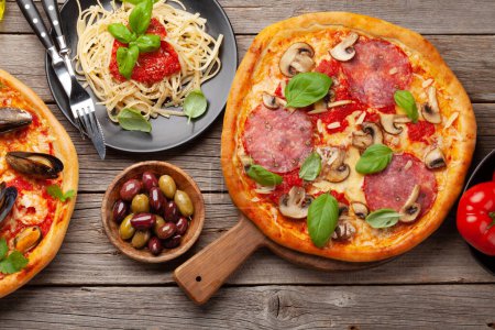 Foto de Cocina italiana. Pastas, pizza, aceitunas y tostadas antipasto. Puesta plana - Imagen libre de derechos