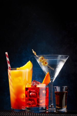 Photo for Negroni, tequila sunrise and martini cocktails on dark background with copy space - Royalty Free Image