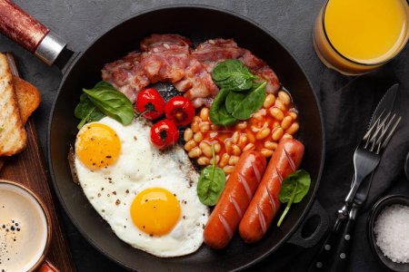 Téléchargez les photos : Petit déjeuner anglais avec œufs frits, haricots, bacon et saucisses. Coucher plat avec café et jus d'orange - en image libre de droit