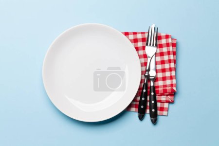 Téléchargez les photos : Assiette vide et argenterie sur fond bleu. Vue de dessus plat couché avec espace de copie. Modèle ou maquette pour votre repas - en image libre de droit