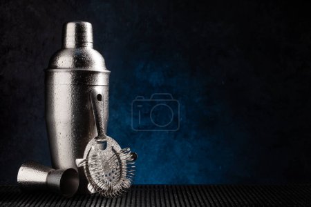 Photo for Cocktail shaker and bar utensils on dark background with copy space - Royalty Free Image