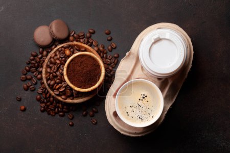 Foto de Café fresco en tazas para llevar, granos de café tostados y café molido. Vista superior plano laico - Imagen libre de derechos