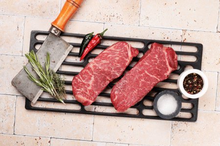Téléchargez les photos : Des steaks de bœuf marbrés. Bifteck de striploïne cru. Pose plate - en image libre de droit