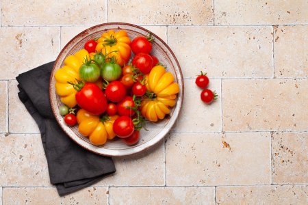 Foto de Varios tomates coloridos del jardín. Verduras frescas y especias. Vista superior plano con espacio de copia - Imagen libre de derechos