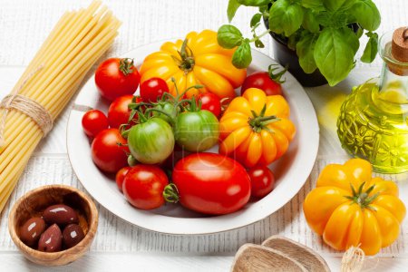 Foto de Varios tomates coloridos del jardín. Verduras frescas y pasta - Imagen libre de derechos