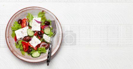 Foto de Ensalada griega con verduras frescas y queso feta. Piso con espacio de copia - Imagen libre de derechos