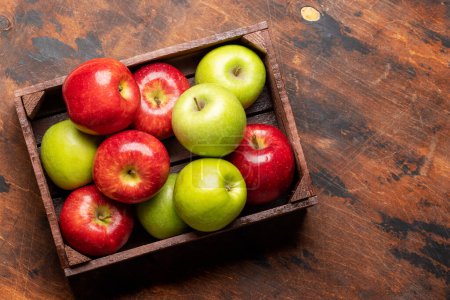 Foto de Manzanas rojas y verdes de jardín en caja de madera. Piso con espacio de copia - Imagen libre de derechos