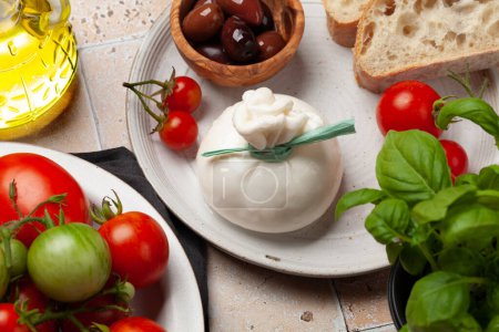 Téléchargez les photos : Fromage burrata, tomates et olives variées. Cuisine italienne - en image libre de droit