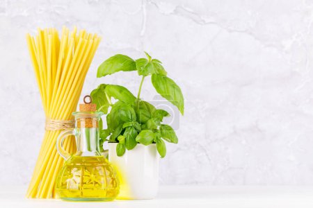 Photo for Ingredients for cooking. Italian cuisine. Pasta, olive oil, basil. With copy space - Royalty Free Image