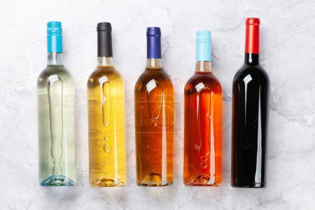 Téléchargez les photos : Diverses bouteilles de vin sur table en pierre. Pose plate - en image libre de droit