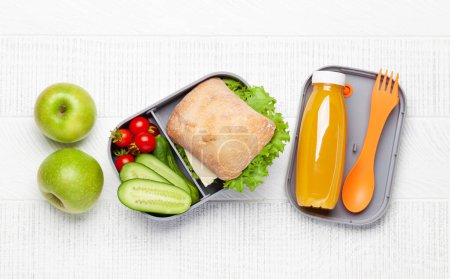 Téléchargez les photos : Boîte à lunch avec sandwich, légumes et jus de fruits. Repas d'école ou de bureau. Pose plate - en image libre de droit
