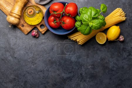 Foto de Ingredientes para cocinar. Cocina italiana. Pastas, tomates, albahaca. Piso con espacio de copia - Imagen libre de derechos